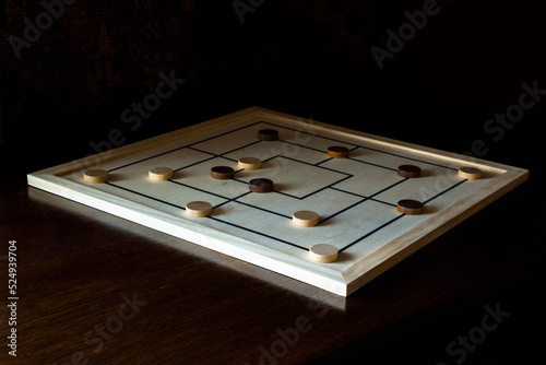 Playing mill game on a wooden table photo