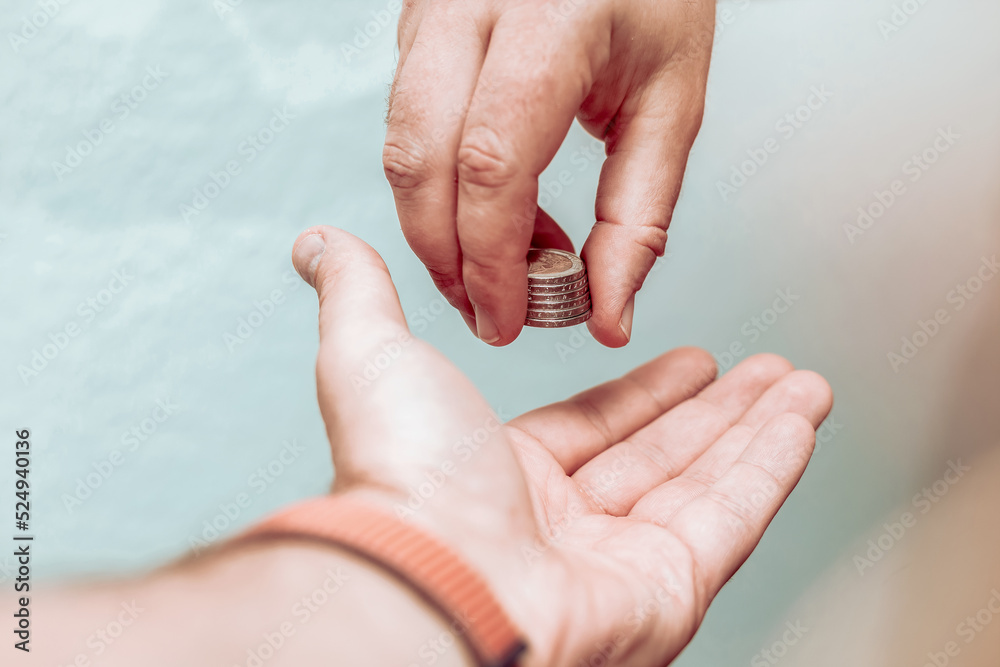 Close up of male hand putting coin into another hand, donation. Close up of male hand putting coin into another hand, donation.