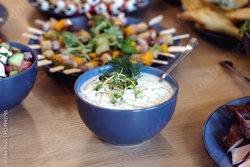 Grecki jogurt, tzaziki, z ziołami i ogórkiem, miska sałatki. photo