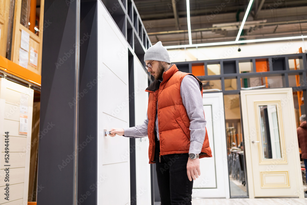 a male buyer in a hardware store chooses wooden interior panel doors