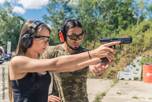 Εκτύπωση καμβά Male instructor showing female client how to aim handgun