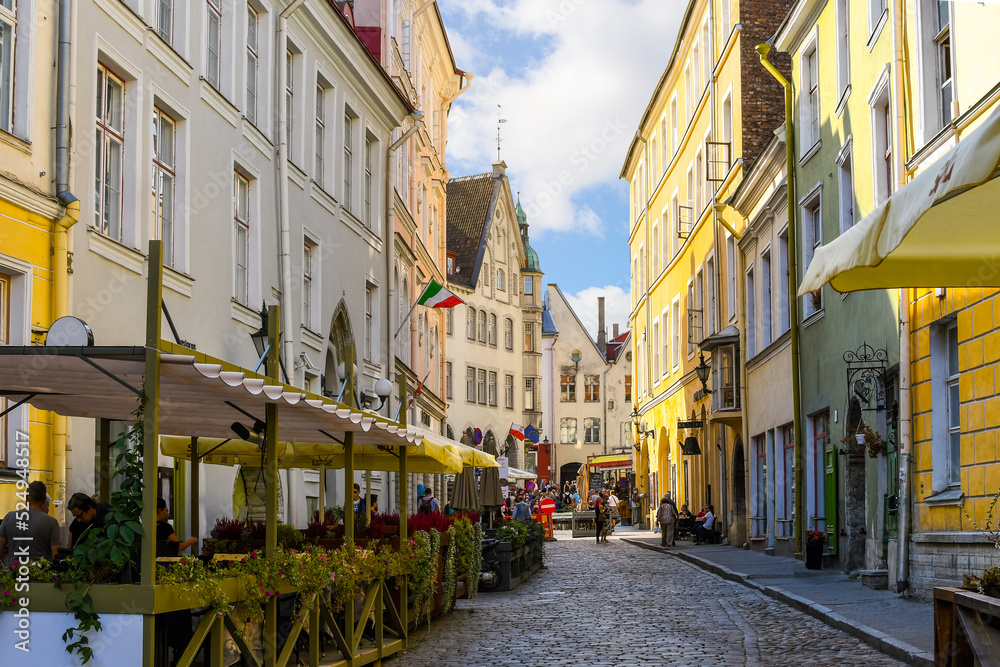 Obraz na płótnie A picturesque cobbled street of sidewalk cafes and shops near the Bishop's House in the medieval old town of Tallinn, in the Baltic region of Northern Europe. w salonie