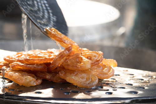 Fresh Cooked Hot Rasdar Jalebi Also Known As Jilapi, Jilebi, Jilipi, Zulbia, Jerry, Zalebi, Mushabak Mithai Made From Fermented Maida And Besan Dunked In Sugar Syrup Cheeni Ki Chasni Or Paag photo