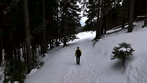 Lone man walking through snow. Mountain expedition. Epic Aerial steady view