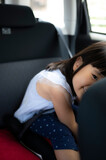 車のチャイルドシートに座る5歳の女の子