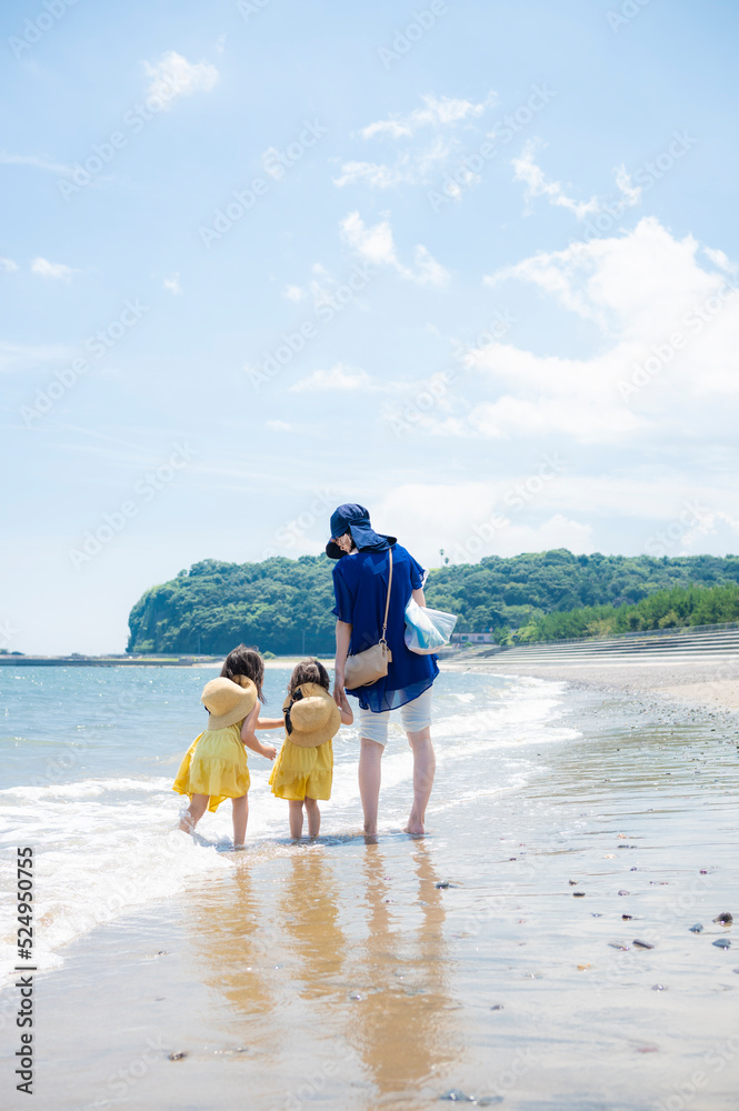 真夏の海の砂浜と青い空と親子