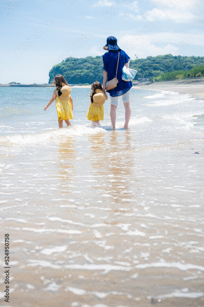 真夏の海の砂浜と青い空と親子