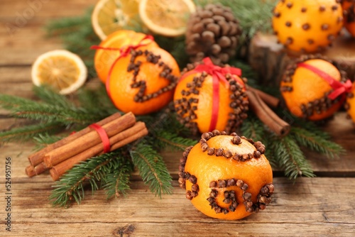 Pomander ball made of fresh tangerine and cloves on wooden table, space for text