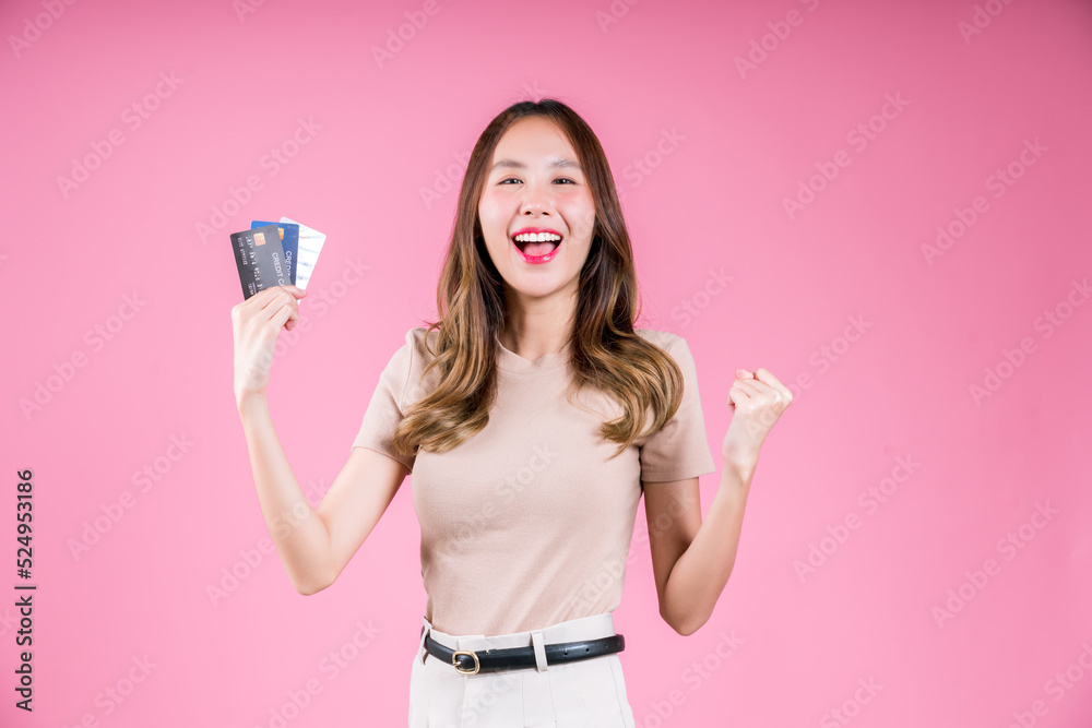 Asian woman happy excited hold credit card for shopping online, Female customer payment internet online shop on the pink background Asian woman happy excited hold credit card for shopping online, Female customer payment internet online shop on the pink background