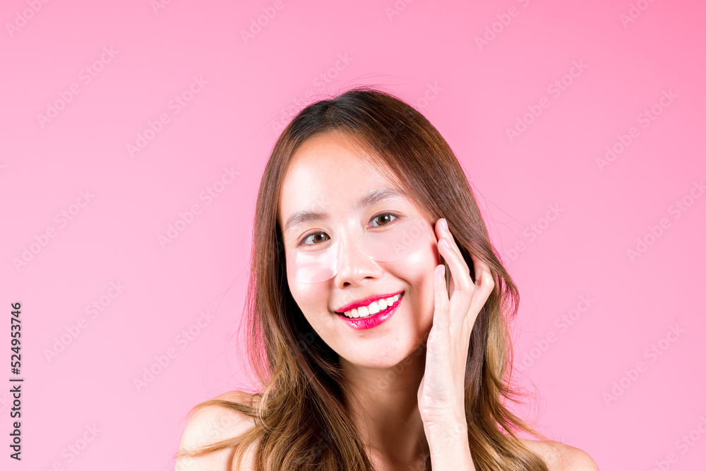 Eye tretment rejuvenation on her under eyes, Facial skin care makeup of Beauty attractive young asian woman applying concept on the pink backgound Eye tretment rejuvenation on her under eyes, Facial skin care makeup of Beauty attractive young asian woman applying concept on the pink backgound