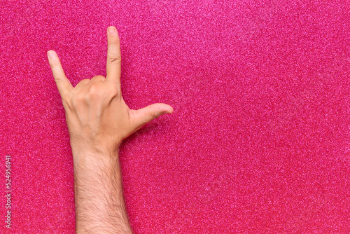 hand gesture horns rock and roll skateboarding with 3 fingers on pink background with glitter