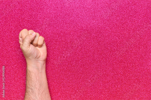 man fist on pink glitter background claiming equality feminism