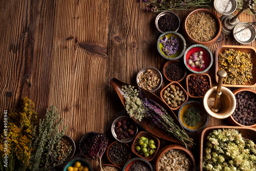 Natural medicine background. Assorted dry herbs in bowls, mortar and plants on rustic wooden table. Natural medicine background. Assorted dry herbs in bowls, mortar and plants on rustic wooden table.