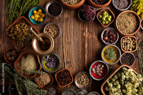 Natural medicine background. Assorted dry herbs in bowls  mortar and plants on rustic wooden table.