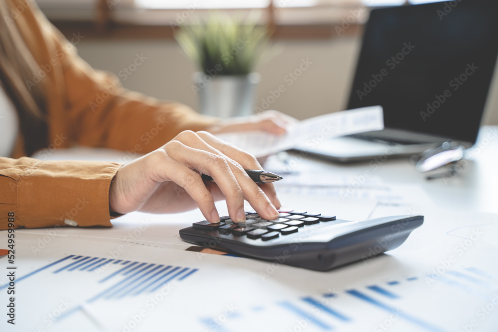 Fototapeta premium person using calculator calculating tax refund on the table
