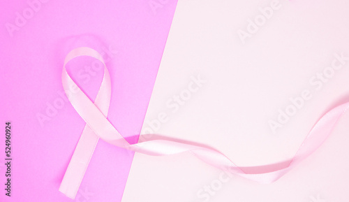 light pink ribbon breast cancer on pink paper background