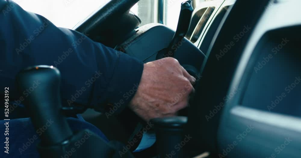 A hand of a man starting a truck engine.