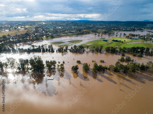 Patch of farmland paddock cut off by floodwater aerial view over flood and river photo