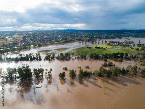 Patch of farmland paddock cut off by floodwater aerial view over flood and river