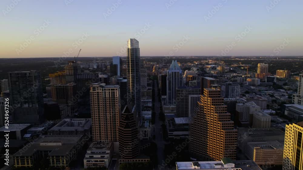 Aerial view flying between buildings on the Congress Ave, towards the Texas state capitol, sunset in Austin, USA