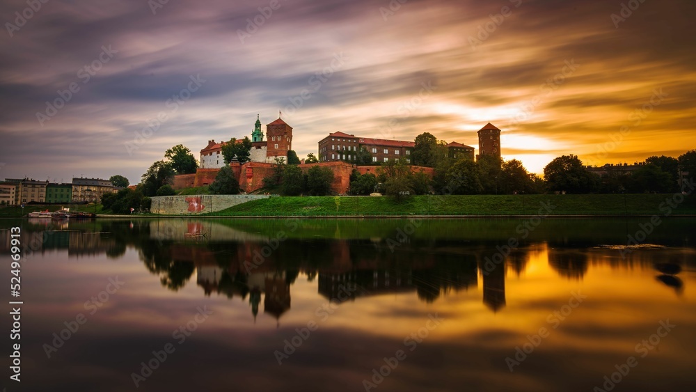 Naklejka premium Zamek Królewski na Wawelu o wschodzie słońca ze złotym niebem w tle