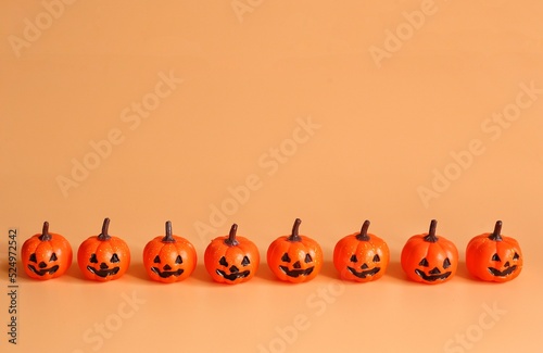 Eight small Beautiful pumpkins on a orange background. Creative halloween concept backdrop. halloween pumpkin toy.