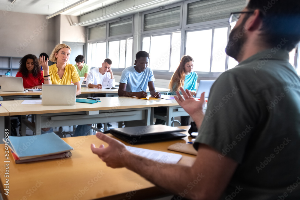 Female college student talking to professor during lecture. Highschool student having conversation with teacher. Female college student talking to professor during lecture. Highschool student having conversation with teacher.