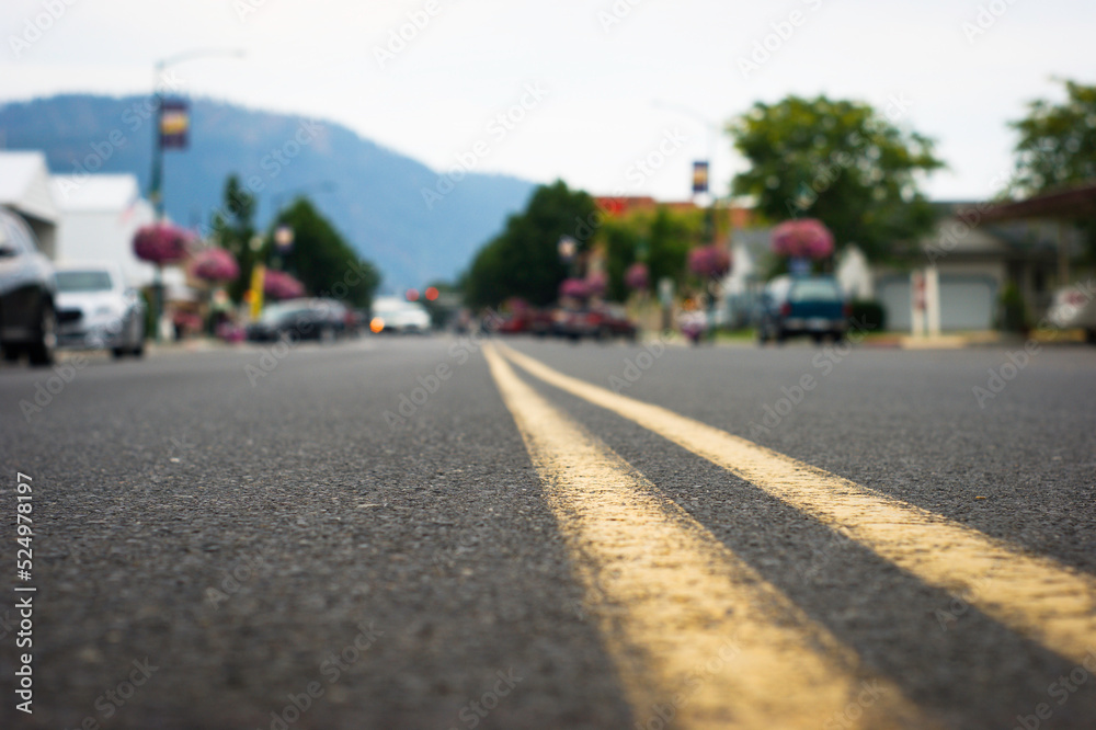 Fototapeta premium Close-up of street line with downtown Chewelah Washington in distance