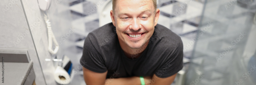 Fototapeta premium Happy young man on the toilet closeup