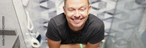 Happy young man on the toilet closeup