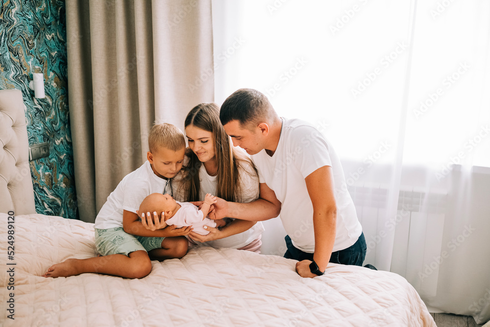 Newborn baby with happy parents and brother. Happy family. Healthy newborn baby with mom and dad. Mother, father and infant baby. Cute Infant girl and parents Newborn baby with happy parents and brother. Happy family. Healthy newborn baby with mom and dad. Mother, father and infant baby. Cute Infant girl and parents