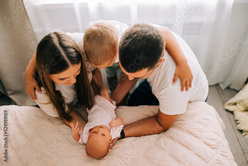 Newborn baby with happy parents and brother. Happy family. Healthy newborn baby with mom and dad. Mother, father and infant baby. Cute Infant girl and parents