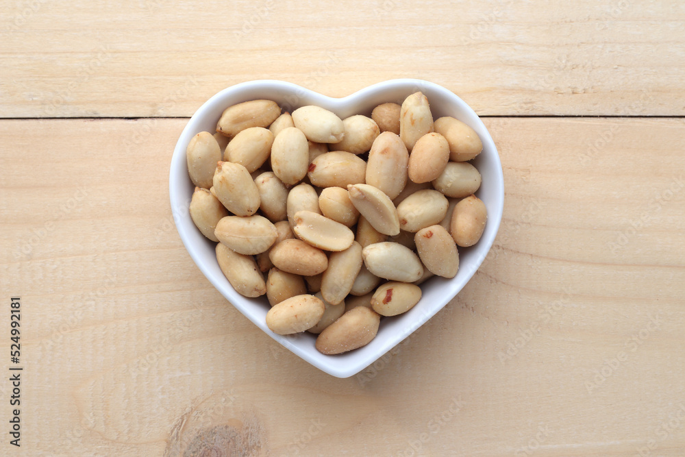 salted peanuts in a heart shaped bowl. salted peanuts in a heart shaped bowl.