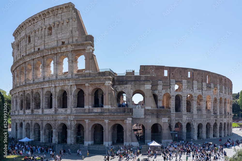 Photo of the West side of the Colosseum with tourists in the foreground (seen from Tempio di Venere e Roma) in Rome