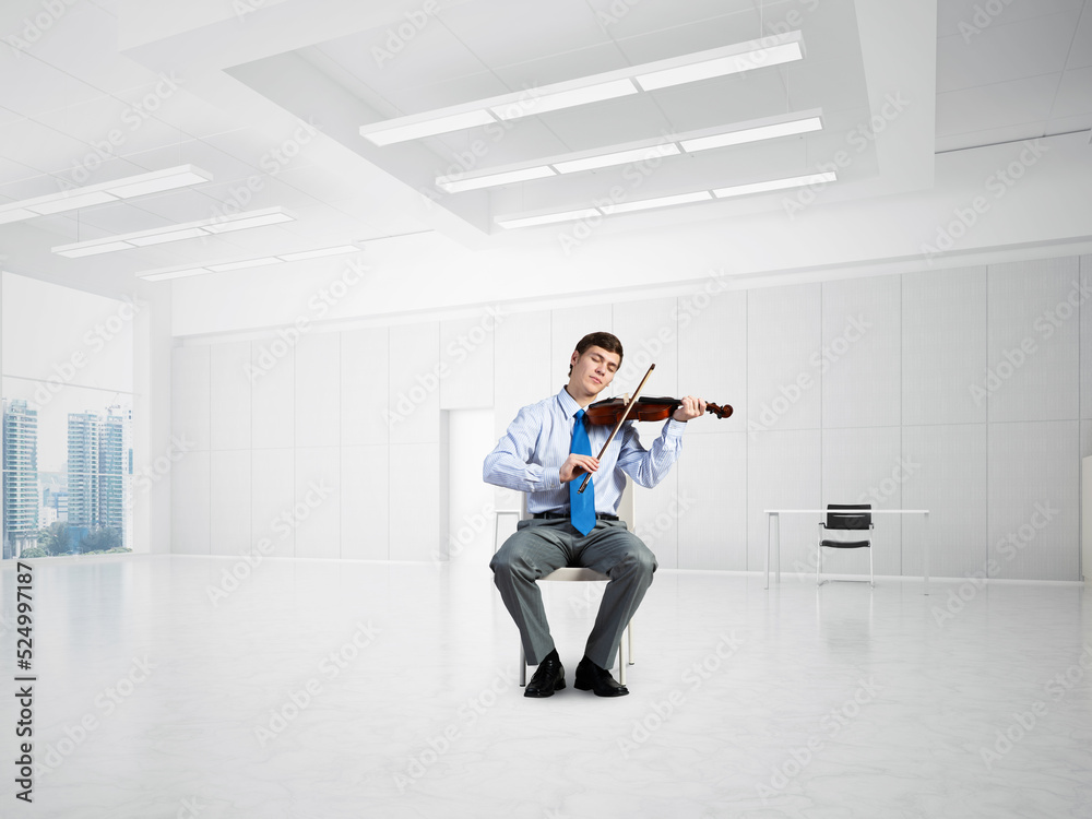 Fototapeta premium young businessman playing violin