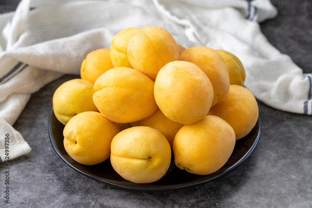 Ripe apricots on a dark background. Fresh and juicy apricots on the plate. Organic food. close up Ripe apricots on a dark background. Fresh and juicy apricots on the plate. Organic food. close up
