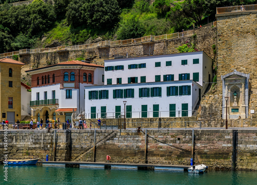 Waterfront houses and a statue of Jose Maria Zubia, framed in a niche overlooking La Concha bay in San Sebastian Donostia, Basque Country, Spain