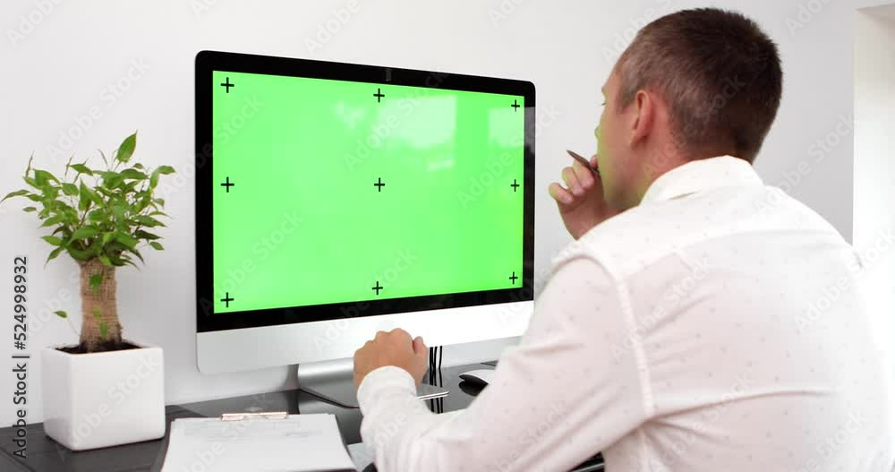 Green screen. Employee working at computer sitting at desk. View from back. Green screen. Employee working at computer sitting at desk. View from back.