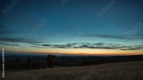 Day to night timelapse view from a hilltop revealing city lights and a starful night sky. 4k. photo