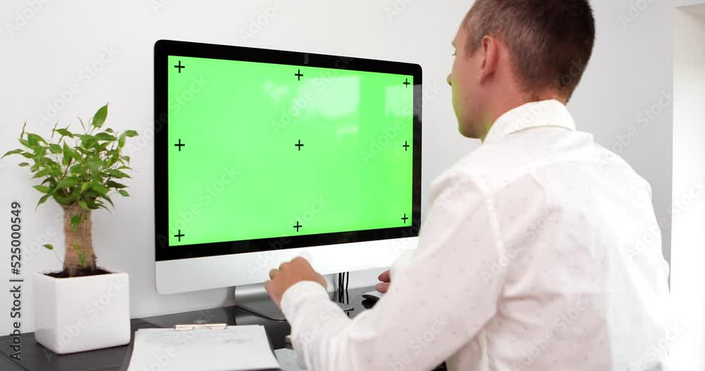 Green screen. Employee working at computer sitting at desk. View from back. Green screen. Employee working at computer sitting at desk. View from back.
