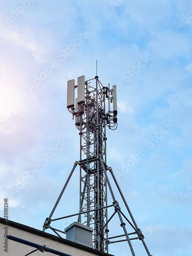 Macro Base Station. 5G radio network telecommunication equipment with radio modules and smart antennas mounted on a metal against cloulds sky background. Telecommunication tower of 4G and 5G cellular.