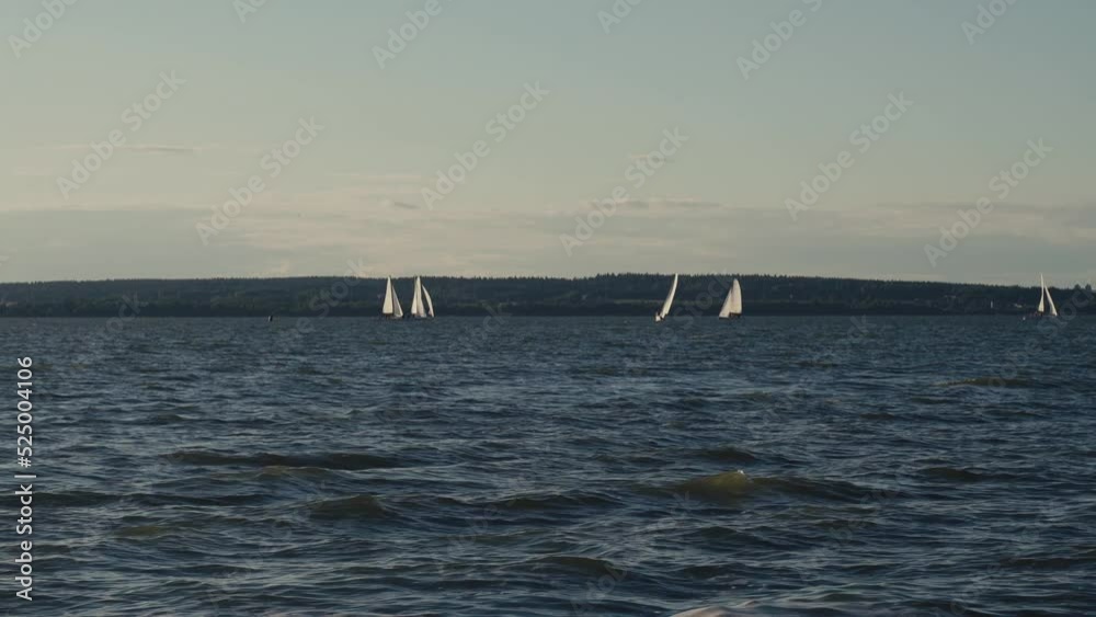 Sports and recreation concept. Yachts with sails move on the surface of the lake. Sports and recreation concept. Yachts with sails move on the surface of the lake.