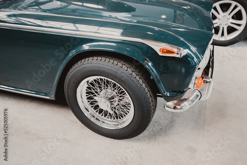 A close-up of the details and wheels of a retro car on display at the automobile museum.