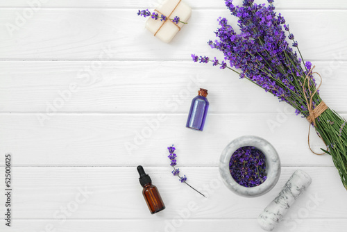 Lavender soap bars and spa products with lavender flowers on a white wooden table