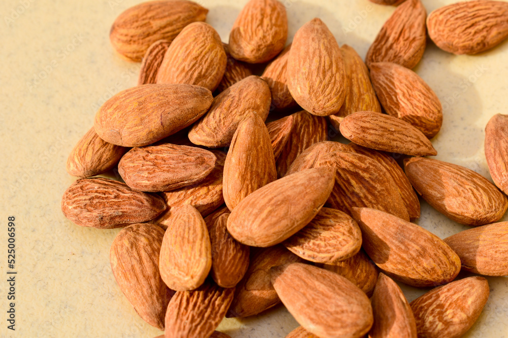 Fototapeta premium Almonds on wooden table background. Close up