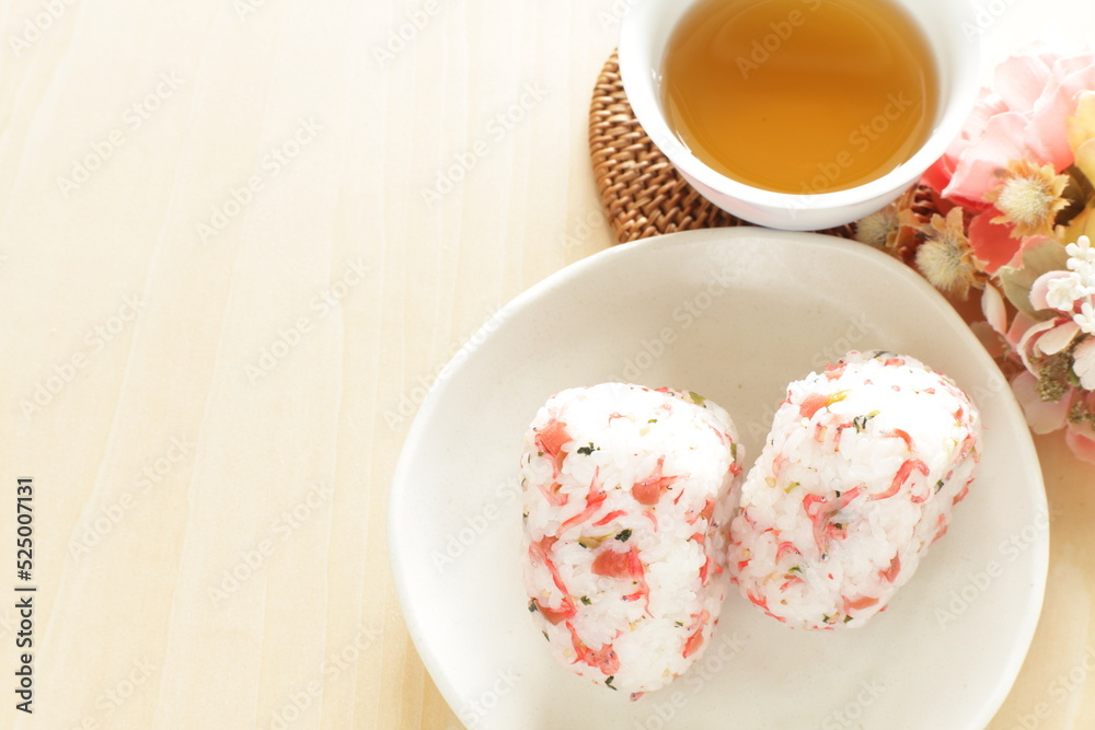 Japanese food, dried plum and small fishes mixed rice ball with barley tea Japanese food, dried plum and small fishes mixed rice ball with barley tea