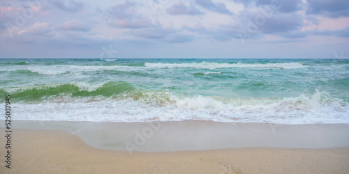 velvet season seascape. waves rushing on the beach. cloudy sky before the evening storm