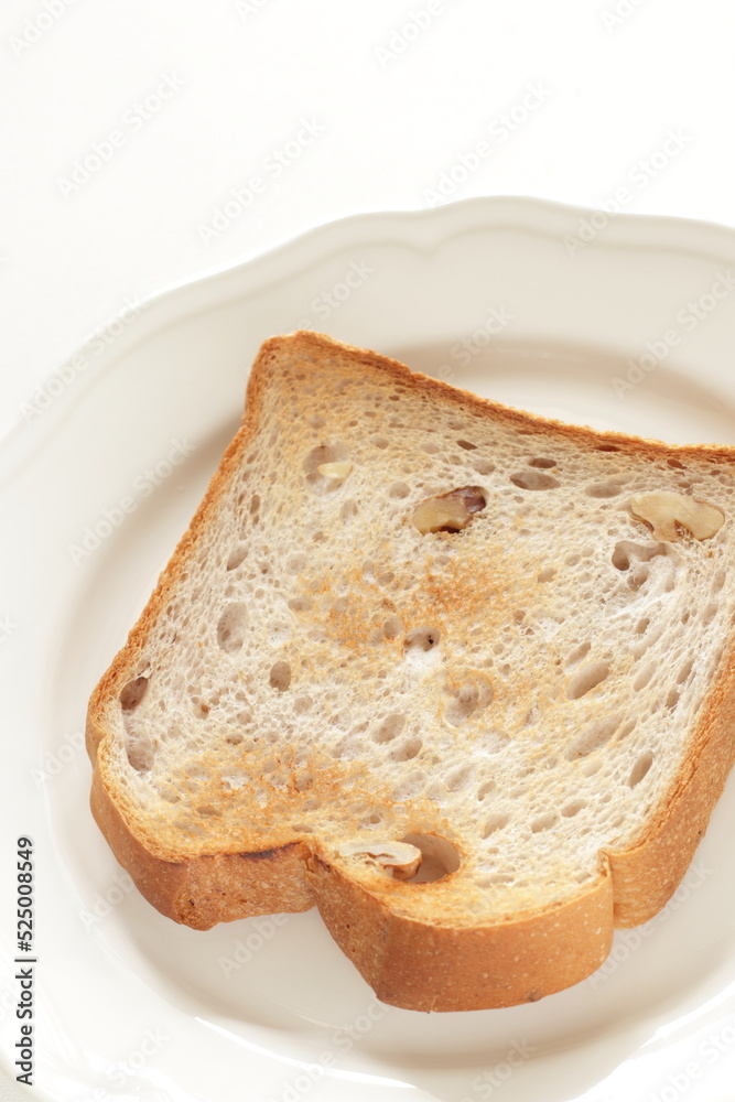 Toasted walnut bread on white dish with copy space Toasted walnut bread on white dish with copy space