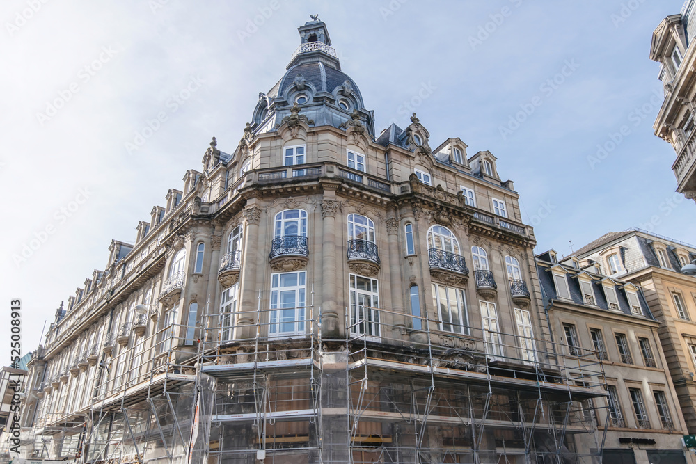 high scaffolding construction on the vintage facade of old French apartment luxury building - renovation of the historical place