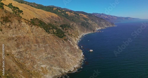 Flying over the mountains descending into the deep ocean. Wonderful scenery of amazing rocky landscape on sunny day in Big Sur Morro Bay, California, United States. photo